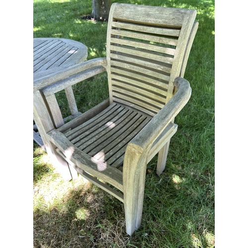 119 - GARDEN ARMCHAIRS, a pair, well weathered teak each stacking with shaped arms together with a circula... 