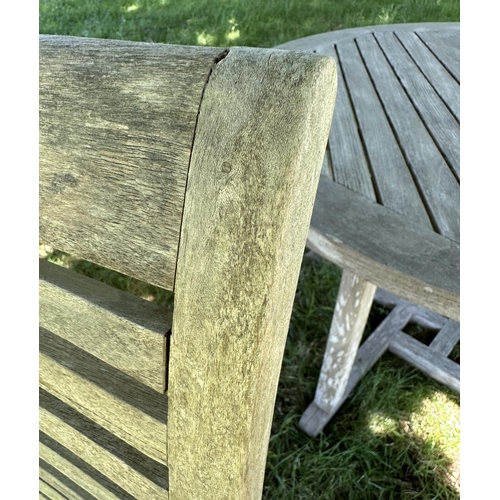 119 - GARDEN ARMCHAIRS, a pair, well weathered teak each stacking with shaped arms together with a circula... 