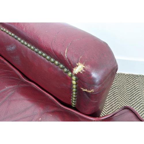 187 - CLUB ARMCHAIR, mid 20th century American red leather, 88cm H x 76cm W and a stool with ball castors,... 