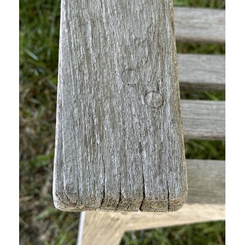 120 - GARDEN BENCH, well weathered slatted teak with flat arms, 82cm H 127cm W.