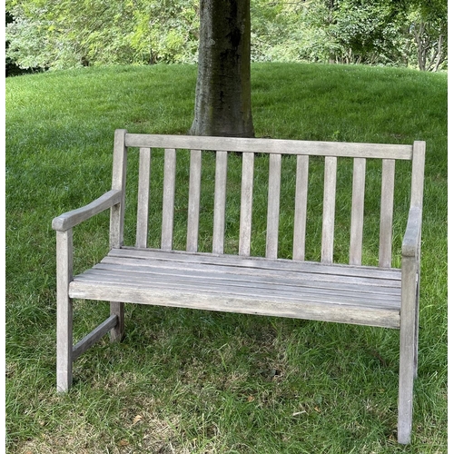 124 - GARDEN BENCH, well weathered slatted teak with shaped arms, 89cm H x 120cm W.