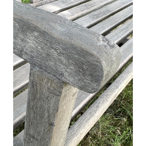 124 - GARDEN BENCH, well weathered slatted teak with shaped arms, 89cm H x 120cm W.