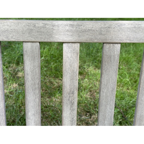 124 - GARDEN BENCH, well weathered slatted teak with shaped arms, 89cm H x 120cm W.