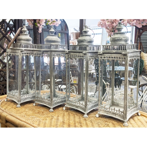 412 - STORM LANTERNS, a set of four, aged finished metal and glazed, 53cm H at tallest. (4)