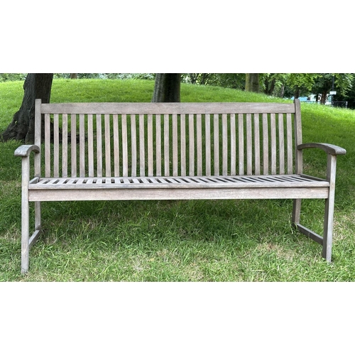 129 - GARDEN BENCH, weathered teak of slatted construction with slightly arch shaped back and curved arms,... 