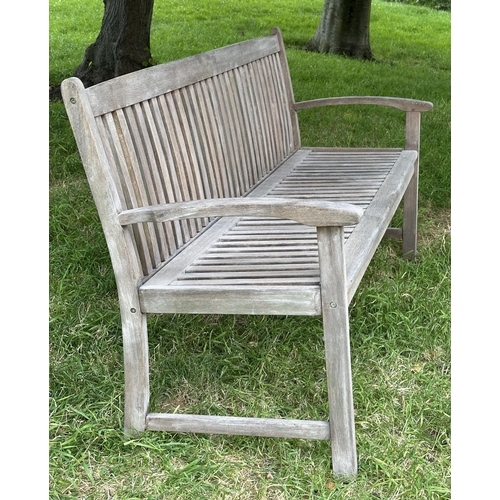 129 - GARDEN BENCH, weathered teak of slatted construction with slightly arch shaped back and curved arms,... 