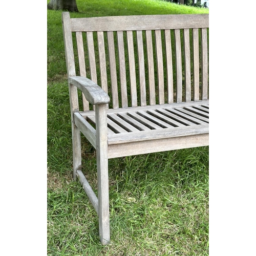 129 - GARDEN BENCH, weathered teak of slatted construction with slightly arch shaped back and curved arms,... 