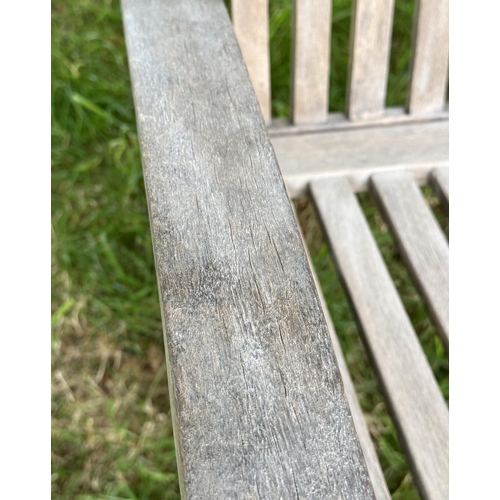 129 - GARDEN BENCH, weathered teak of slatted construction with slightly arch shaped back and curved arms,... 