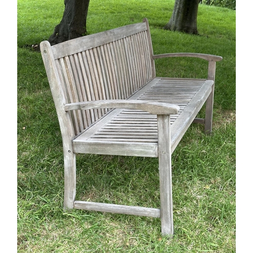 129 - GARDEN BENCH, weathered teak of slatted construction with slightly arch shaped back and curved arms,... 