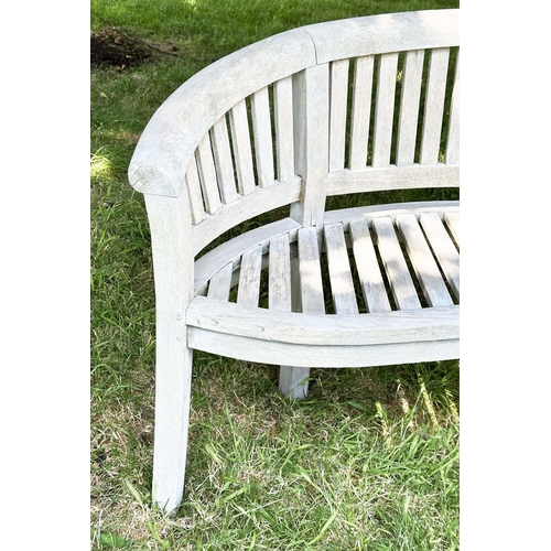 271 - BANANA GARDEN BENCH, well weathered teak of slatted construction with rounded back and arms, 158cm W... 