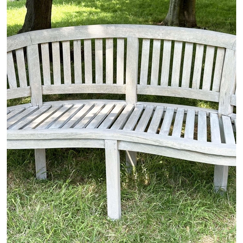 271 - BANANA GARDEN BENCH, well weathered teak of slatted construction with rounded back and arms, 158cm W... 