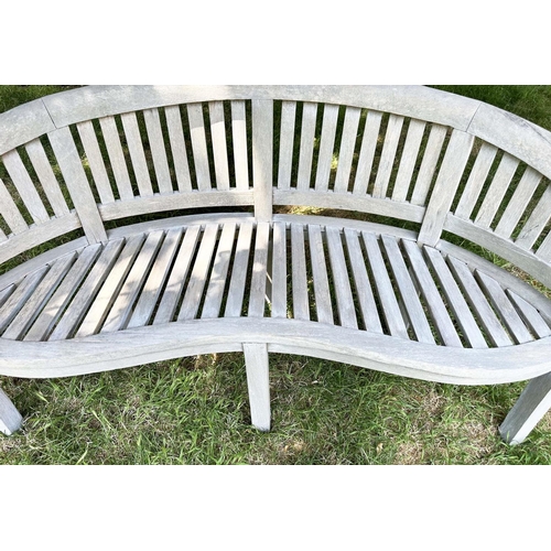 271 - BANANA GARDEN BENCH, well weathered teak of slatted construction with rounded back and arms, 158cm W... 