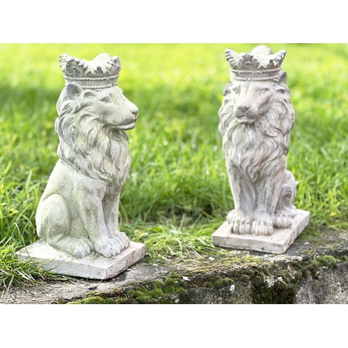 329 - GARDEN LIONS, a pair, weathered composite stone each seated and crowned, 35cm H. (2)