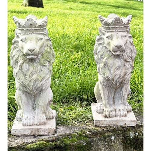 329 - GARDEN LIONS, a pair, weathered composite stone each seated and crowned, 35cm H. (2)