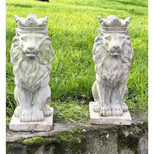 329 - GARDEN LIONS, a pair, weathered composite stone each seated and crowned, 35cm H. (2)