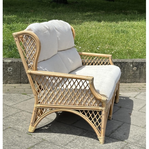 487 - ORANGERY STYLE SOFA, wingback rattan framed and cane bound, two seater with trellis sides and cushio... 