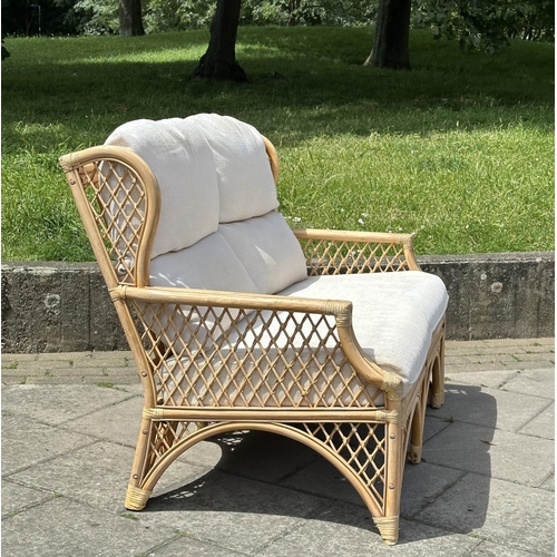 487 - ORANGERY STYLE SOFA, wingback rattan framed and cane bound, two seater with trellis sides and cushio... 