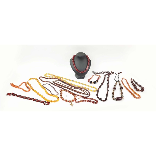 12 - A QUANTITY OF ASSORTED AMBER COLOURED BEAD NECKLACES, some glass and some in plastic, in red and ora... 