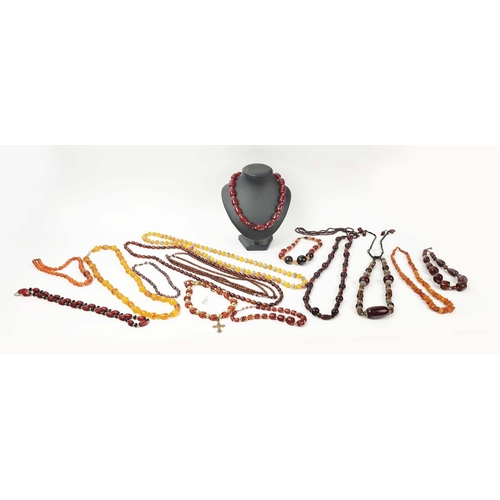 12 - A QUANTITY OF ASSORTED AMBER COLOURED BEAD NECKLACES, some glass and some in plastic, in red and ora... 