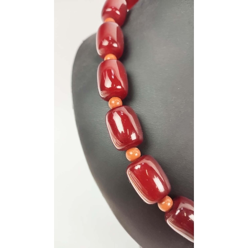 12 - A QUANTITY OF ASSORTED AMBER COLOURED BEAD NECKLACES, some glass and some in plastic, in red and ora... 