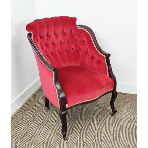 397 - ARMCHAIR, Edwardian with a mahogany showframe and button back red velvet upholstery on steel castors... 