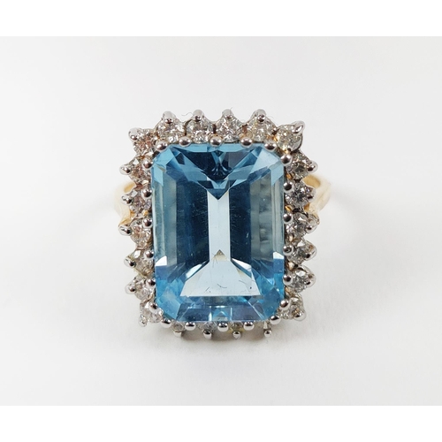 20 - AN 18CT GOLD SWISS BLUE TOPAZ AND DIAMOND RING, the emerald cut topaz surrounded by 22 round brillia... 