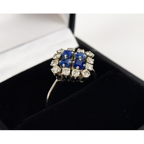 23 - A WHITE METAL DIAMOND AND SAPPHIRE SQUARE SET CLUSTER RING, with four sapphires surrounded by a halo... 