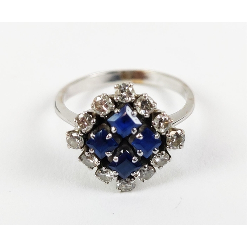 23 - A WHITE METAL DIAMOND AND SAPPHIRE SQUARE SET CLUSTER RING, with four sapphires surrounded by a halo... 