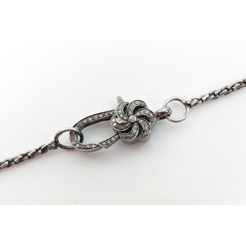 29 - A WHITE METAL CHAIN WITH A DECORATIVE DIAMOND ENCRUSTED CLASP, the clasp with rough cut diamonds to ... 