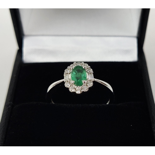 36 - AN 18CT WHITE GOLD EMERALD AND DIAMOND RING, the central oval cut emerald of approximately 0.45 cara... 