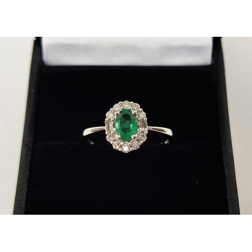 36 - AN 18CT WHITE GOLD EMERALD AND DIAMOND RING, the central oval cut emerald of approximately 0.45 cara... 