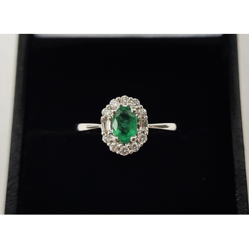 36 - AN 18CT WHITE GOLD EMERALD AND DIAMOND RING, the central oval cut emerald of approximately 0.45 cara... 