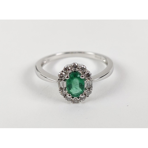 36 - AN 18CT WHITE GOLD EMERALD AND DIAMOND RING, the central oval cut emerald of approximately 0.45 cara... 