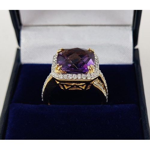 39 - AN 18CT GOLD AMETHYST AND DIAMOND DRESS RING, the central cushion cut amethyst surrounded by round b... 