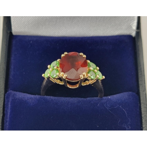 41 - A SPESSARTINE GARNET AND GREEN STONE DRESS RING, 9ct gold shank, the central mixed cut stone surroun... 