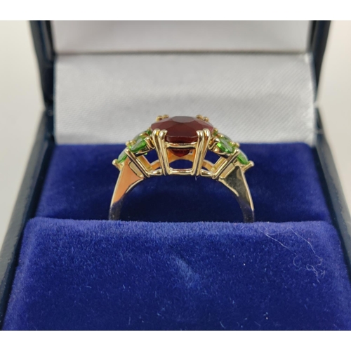 41 - A SPESSARTINE GARNET AND GREEN STONE DRESS RING, 9ct gold shank, the central mixed cut stone surroun... 