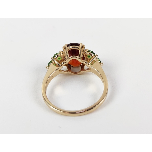 41 - A SPESSARTINE GARNET AND GREEN STONE DRESS RING, 9ct gold shank, the central mixed cut stone surroun... 