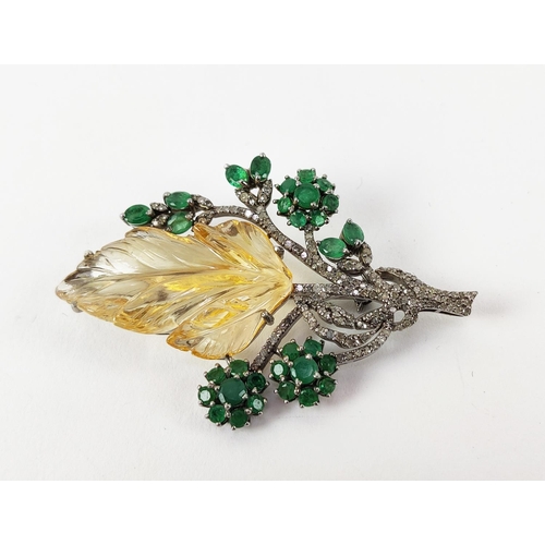 43 - A TREE OF LIFE BROOCH, the central foliage cut citrine, surrounded by round mixed cut emeralds, whit... 