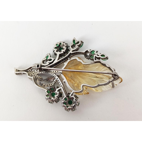 43 - A TREE OF LIFE BROOCH, the central foliage cut citrine, surrounded by round mixed cut emeralds, whit... 