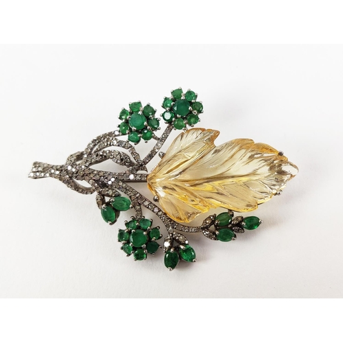 43 - A TREE OF LIFE BROOCH, the central foliage cut citrine, surrounded by round mixed cut emeralds, whit... 