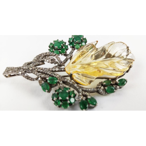 43 - A TREE OF LIFE BROOCH, the central foliage cut citrine, surrounded by round mixed cut emeralds, whit... 