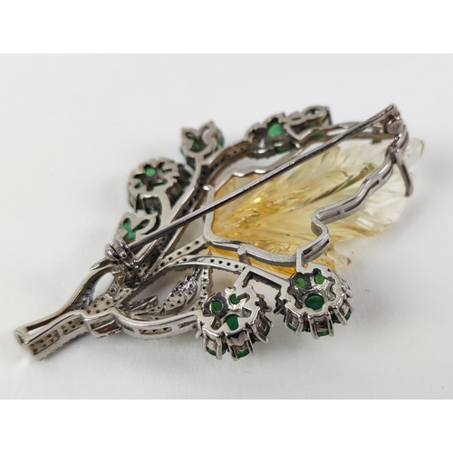 43 - A TREE OF LIFE BROOCH, the central foliage cut citrine, surrounded by round mixed cut emeralds, whit... 