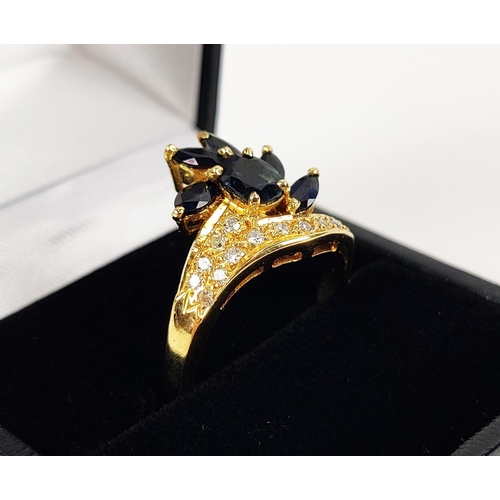 18 - A YELLOW METAL SAPPHIRE AND DIAMOND SET DRESS RING, probably 18ct gold, asymmetrical floral spray wi... 