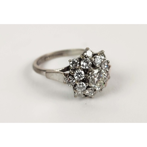 19 - An 18CT WHITE GOLD DIAMOND CLUSTER RING, the central round brilliant cut stone of approximately 0.50... 