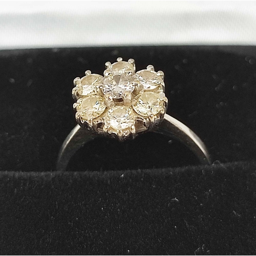 27 - AN 18CT WHITE GOLD SEVEN STONE DIAMOND CLUSTER RING, the round brilliant cut stone of approximately ... 