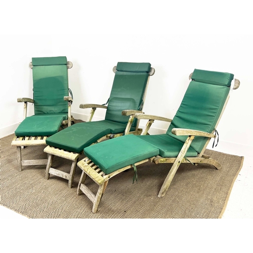 157 - GARDEN STEAMER CHAIRS, a set of three, folding weathered teak with cushions. (3)