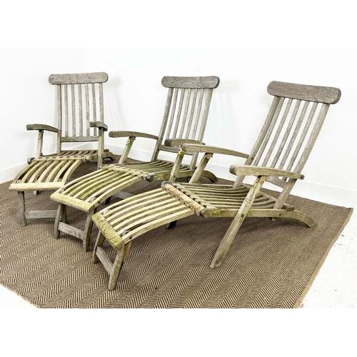 157 - GARDEN STEAMER CHAIRS, a set of three, folding weathered teak with cushions. (3)