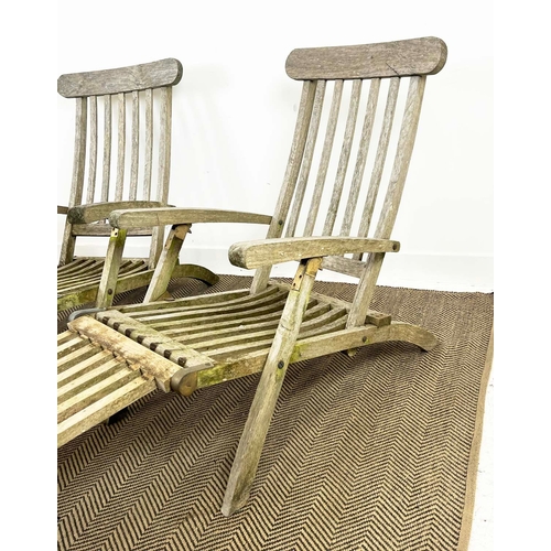 157 - GARDEN STEAMER CHAIRS, a set of three, folding weathered teak with cushions. (3)