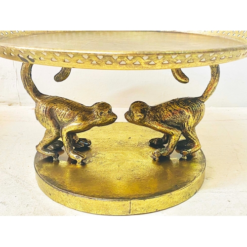 356 - TAZZAS, a pair, gilt finish on monkey supports, 20cm H x 35cm W x 35cm D. (2)