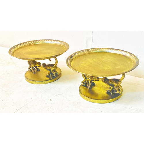 356 - TAZZAS, a pair, gilt finish on monkey supports, 20cm H x 35cm W x 35cm D. (2)